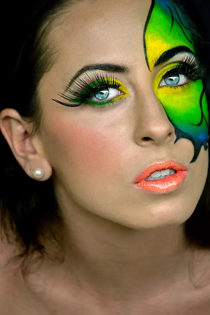 Retrato de belleza con maquillaje artístico: media cara pintada en verde y amarillo estilo alas de mariposa