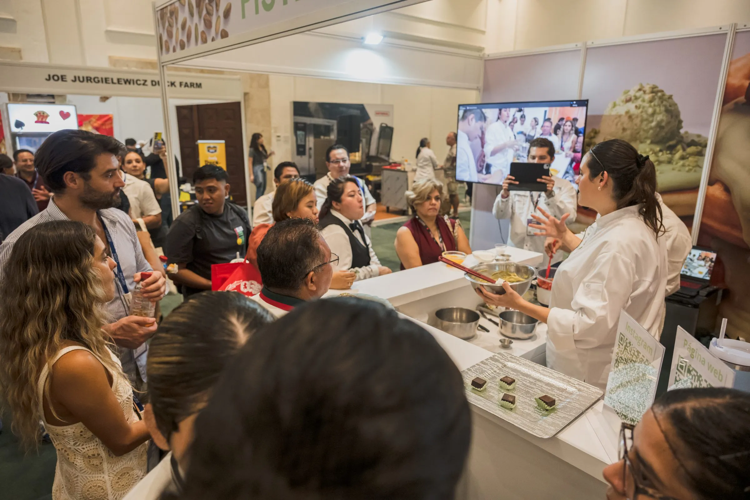 Público reunido alrededor de una demostración culinaria en vivo, energía y escala del evento