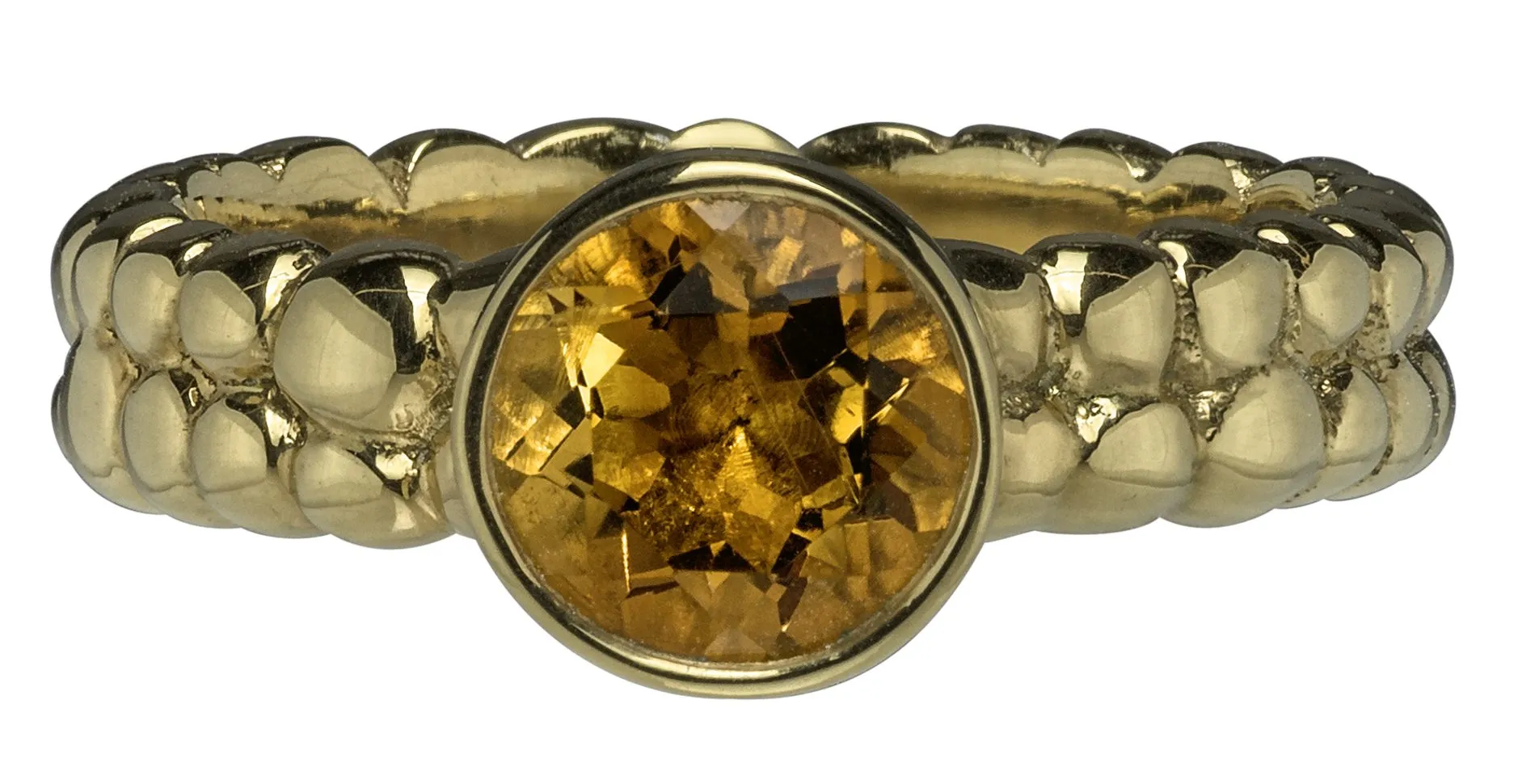 Anillo con piedra citrino y banda texturizada en oro, macro mostrando factura y detalle de terminado