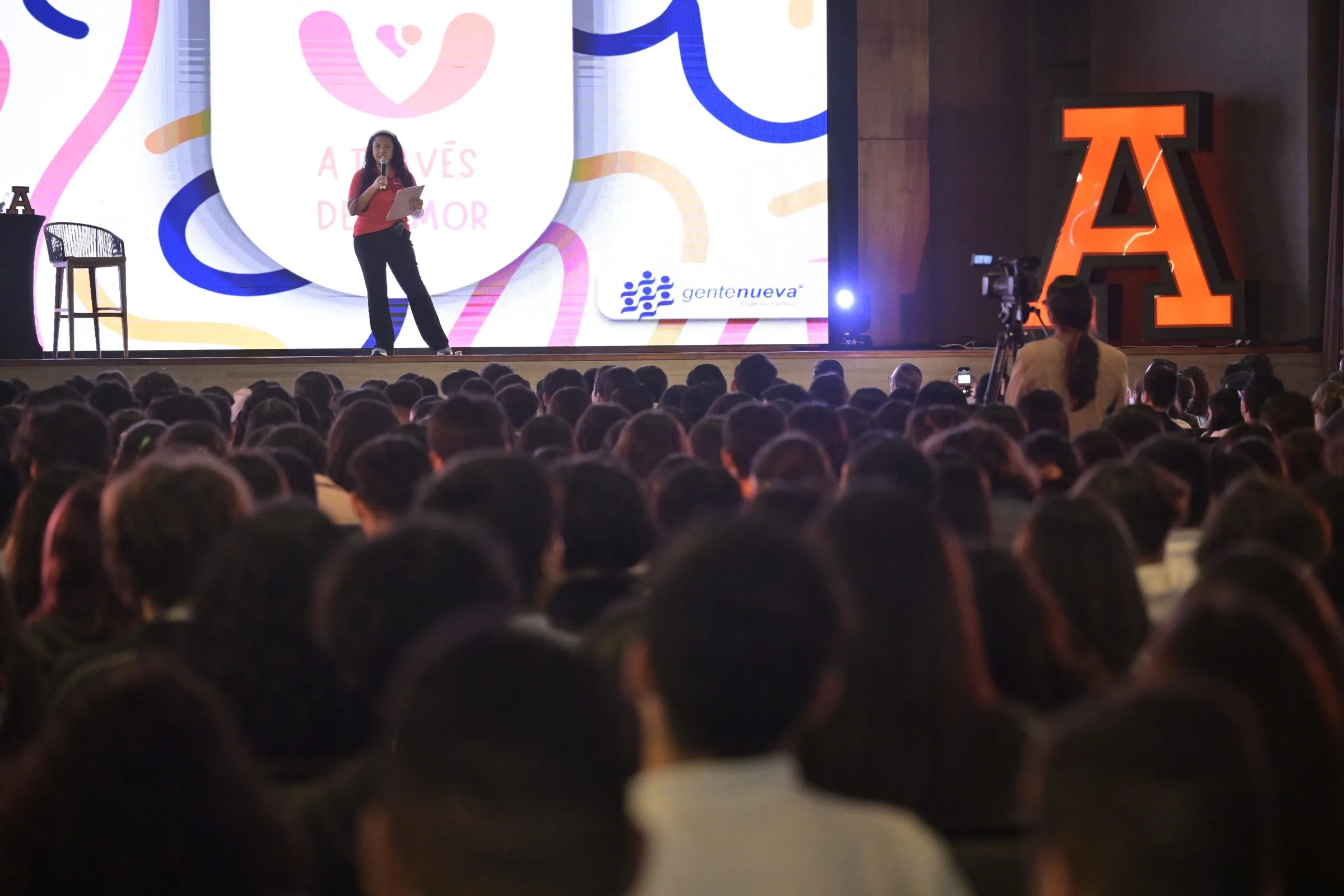Wide shot of a packed auditorium from the stage, showing the event's scale and turnout