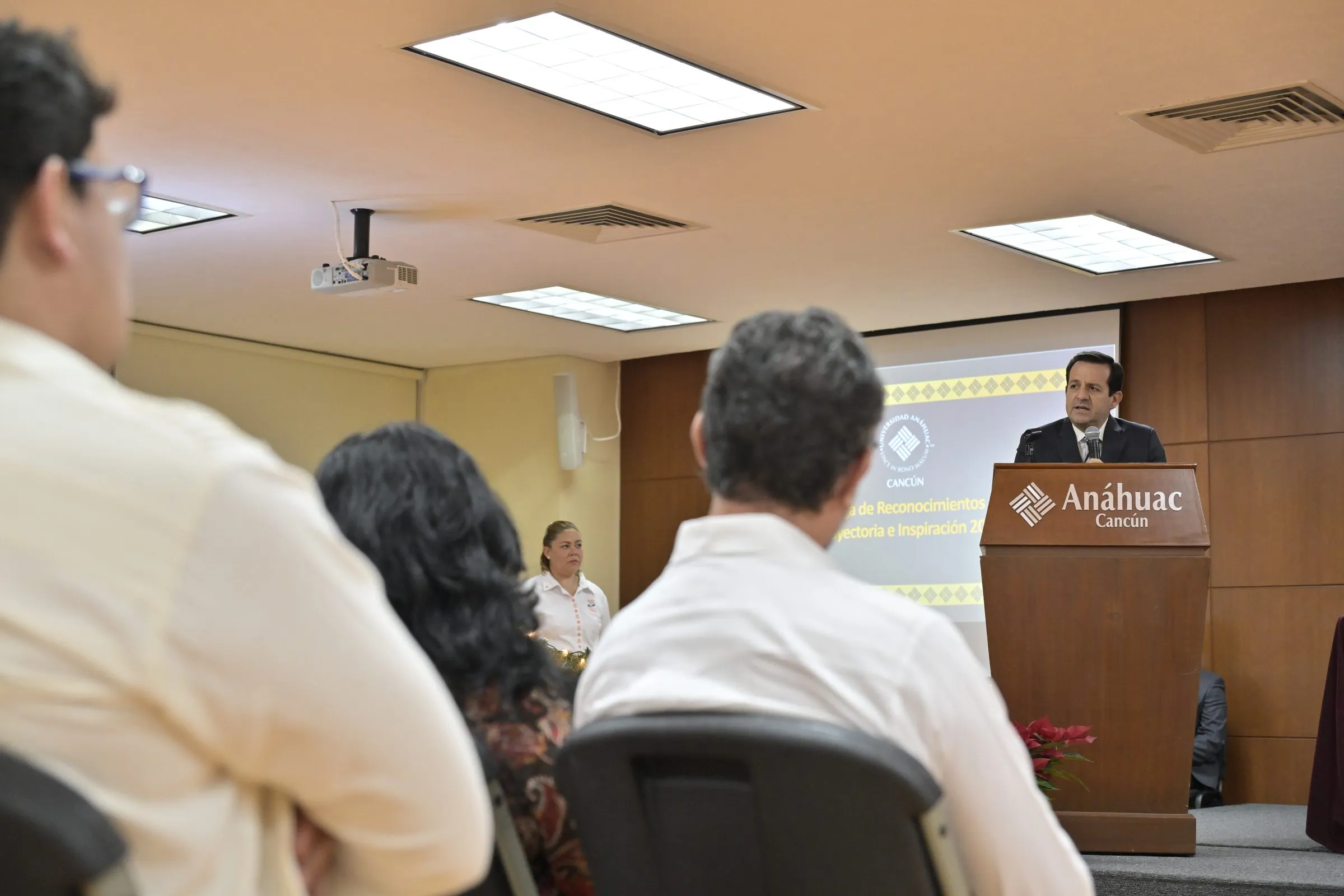 Ponente presentando frente a audiencia pequeña en sala de congreso académico universitario