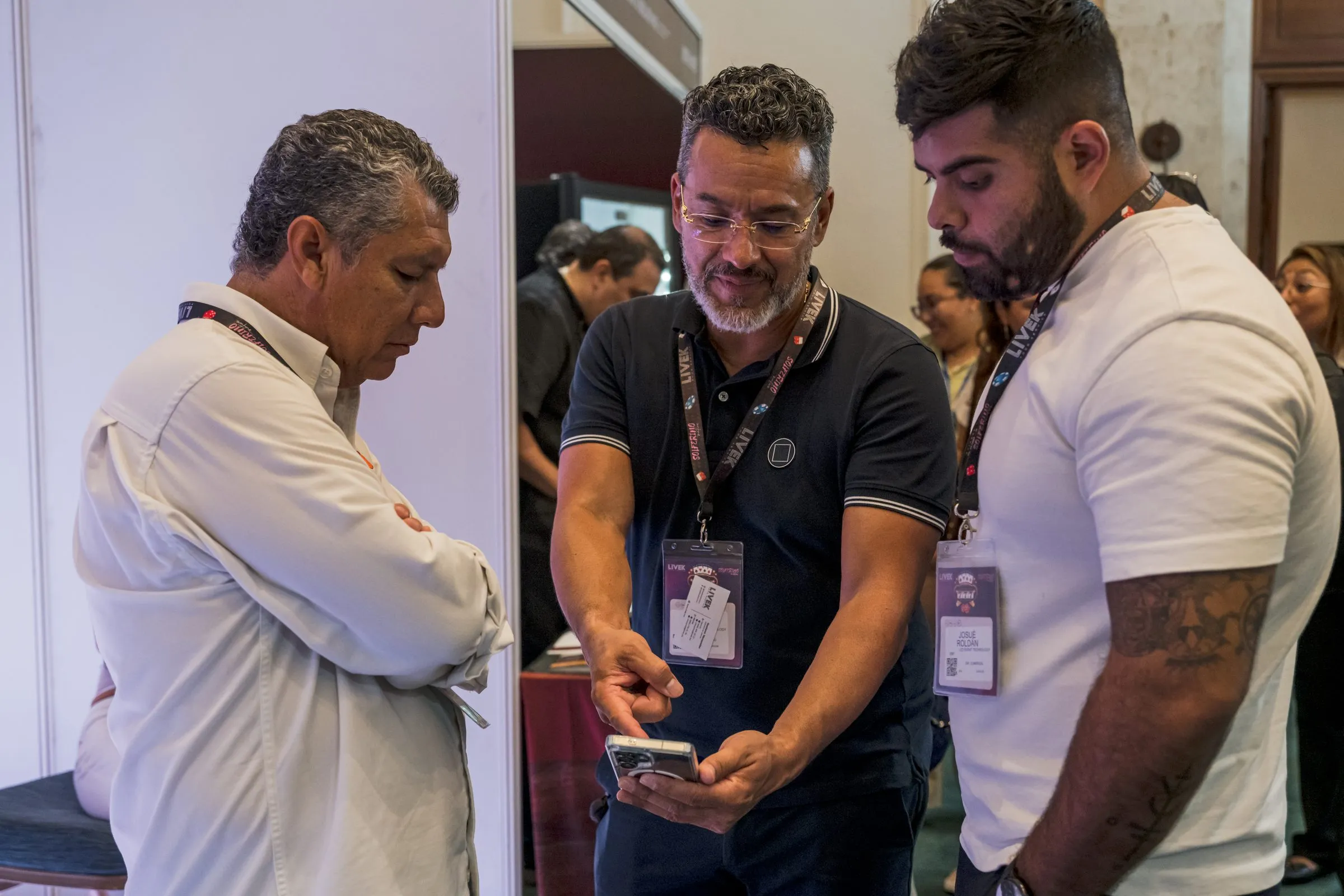 Visitantes conversando con expositor en su stand, branding de marca visible