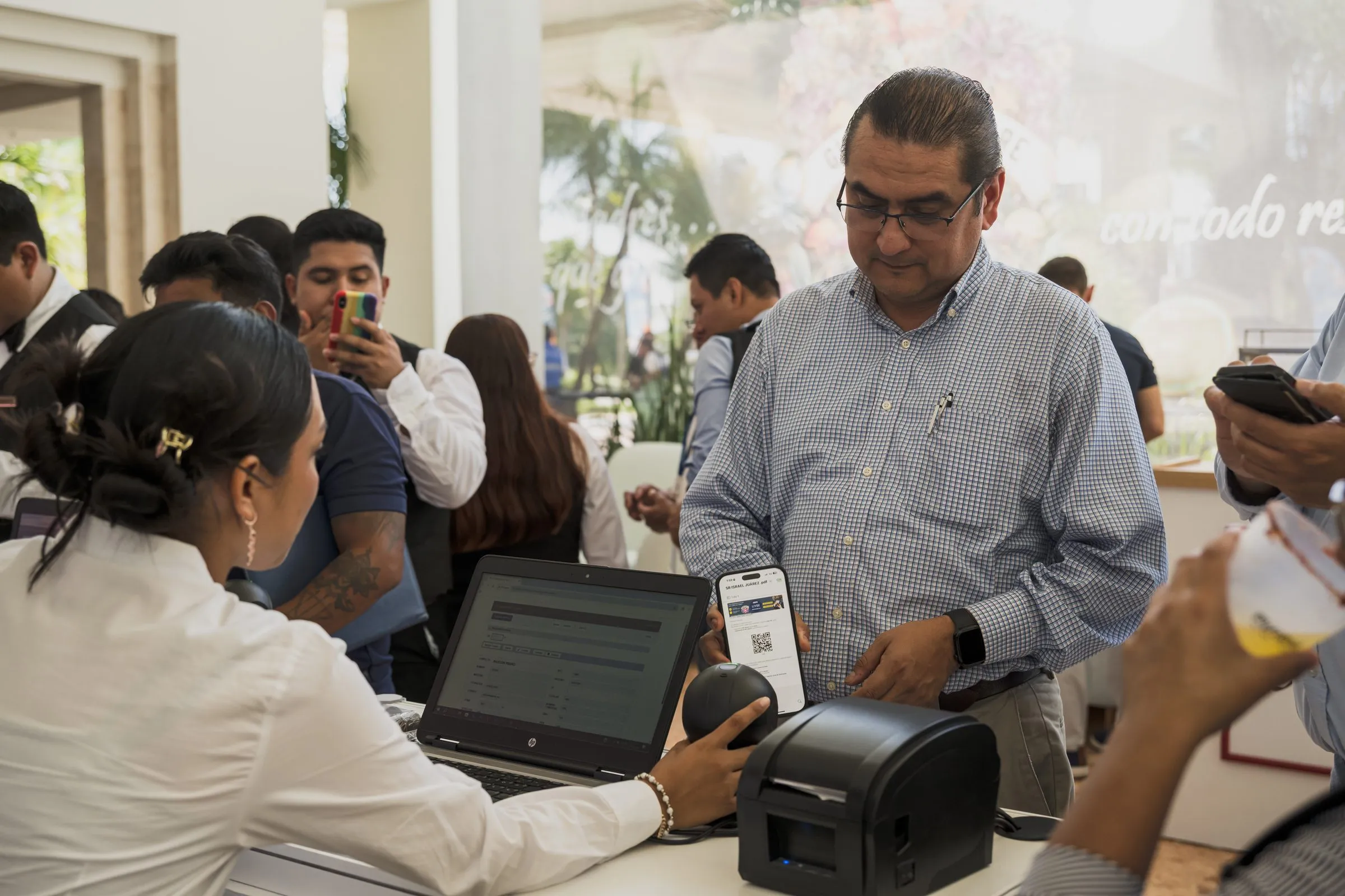 Staff de expositor imprimiendo etiqueta para un visitante en punto de venta del stand
