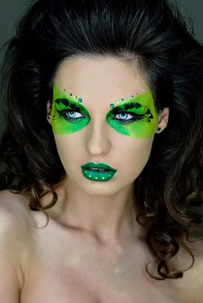 Retrato editorial con maquillaje artístico verde alrededor de los ojos y labios