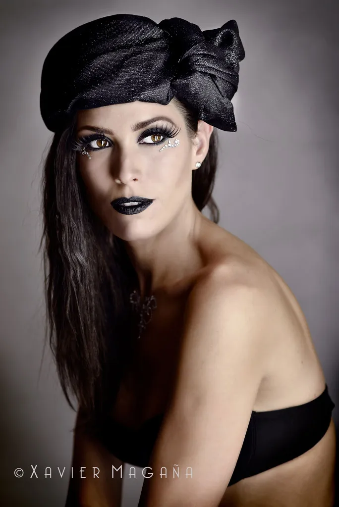 Retrato de moda de una mujer con tocado negro y maquillaje dramático de labios oscuros