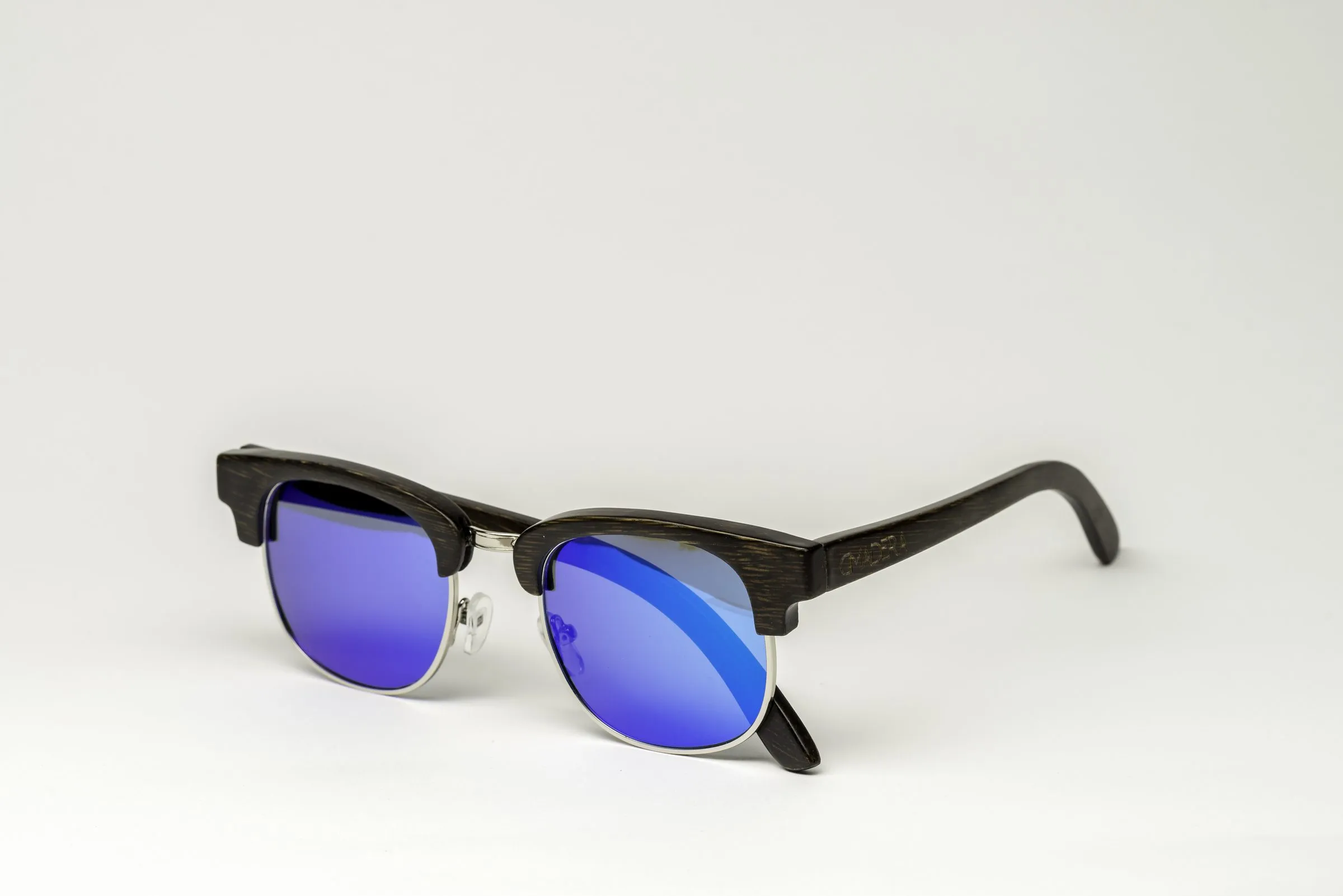Wood clubmaster sunglasses with silver rims and blue-violet mirrored lenses, shot on a white background.
