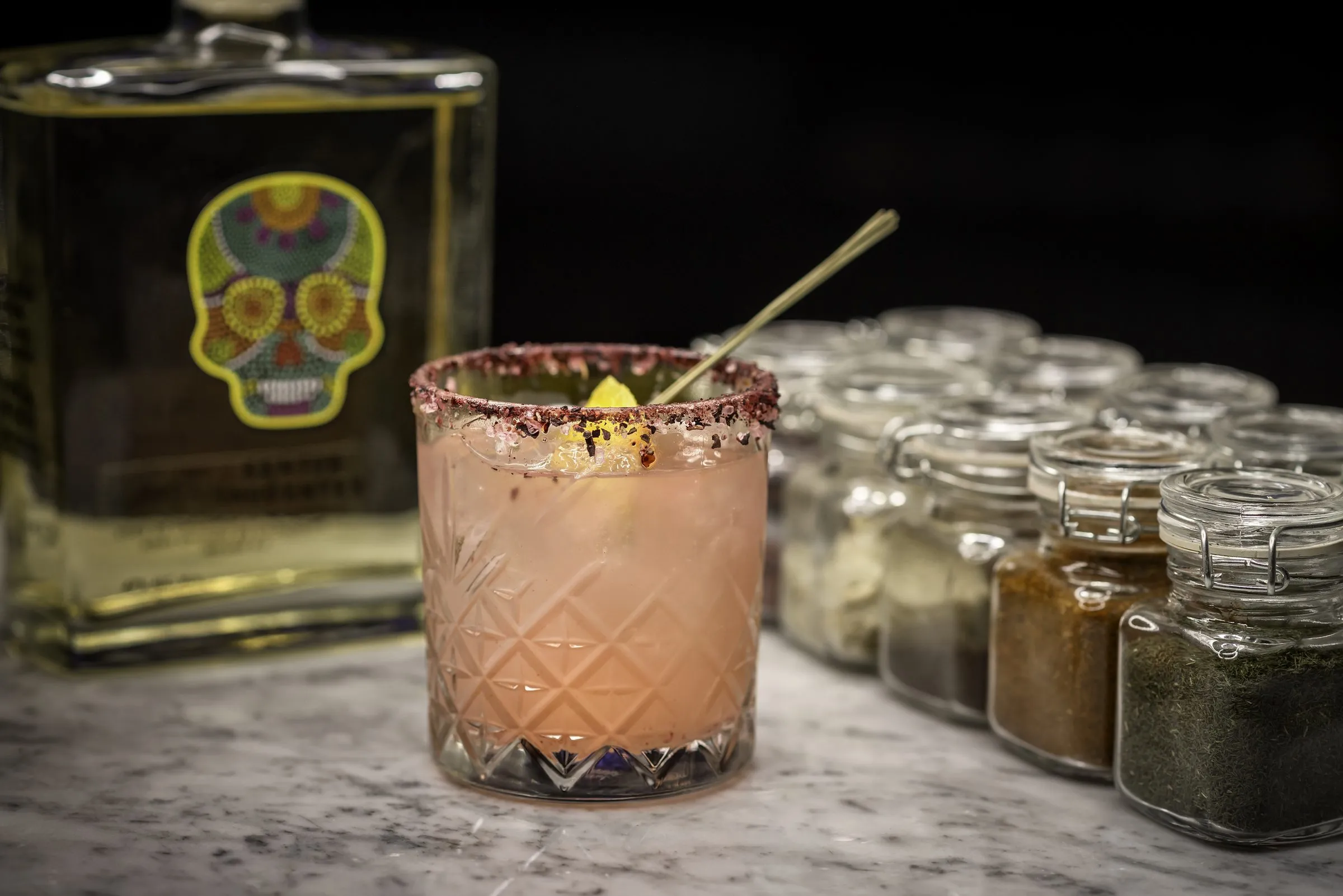 Coctel con botella de licor artesanal, foto profesional de catálogo, calidad que se sostiene meses en publicación