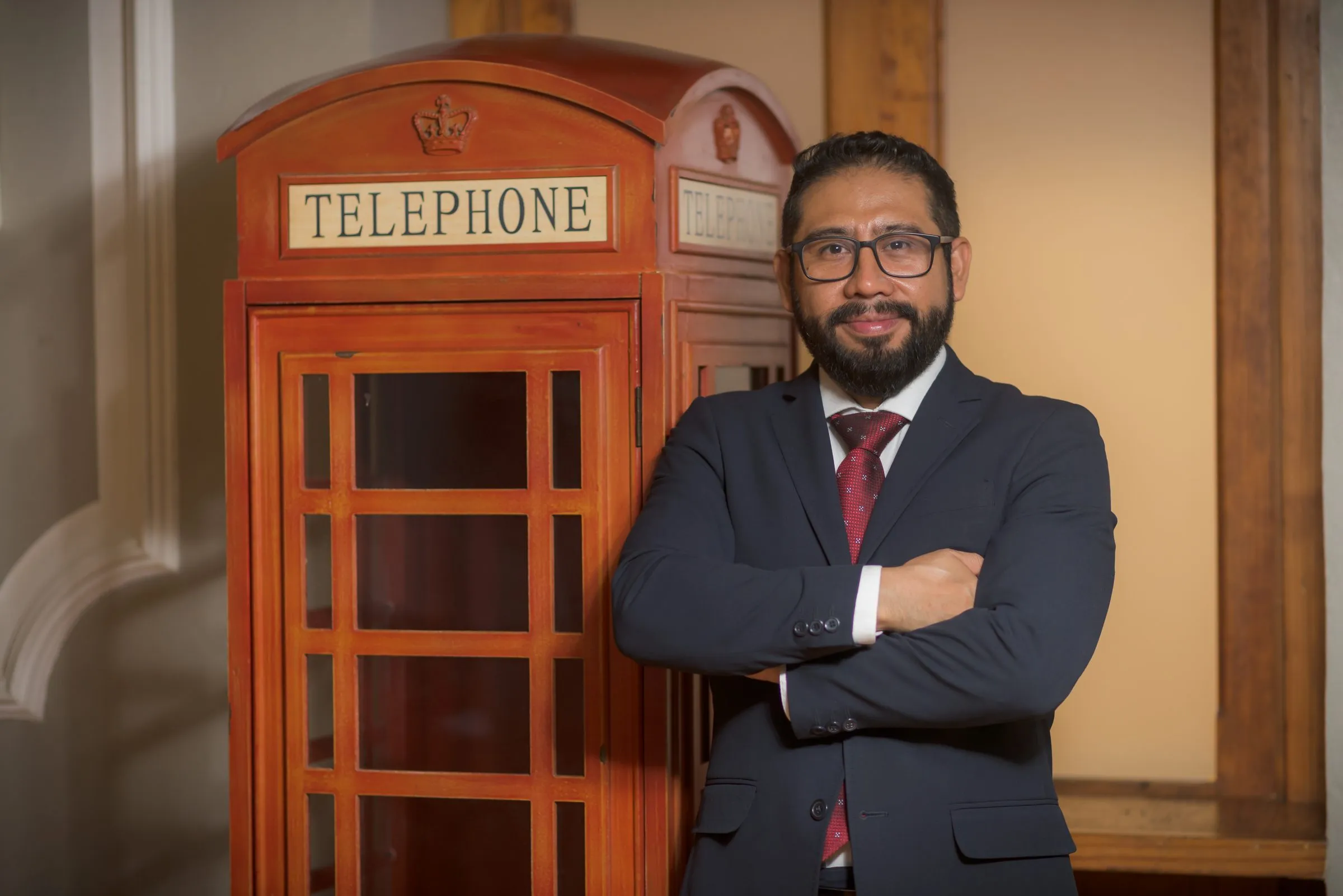 Retrato editorial ambientado junto a una cabina telefónica roja como elemento narrativo, sesión para revista jurídica