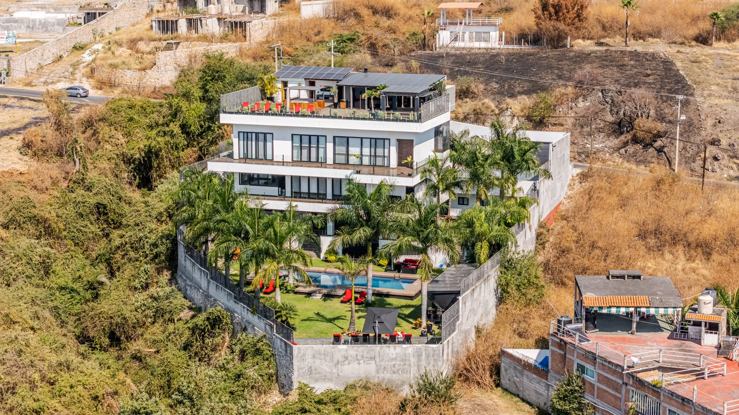 Toma aérea de villa premium con alberca y terreno frente al mar en Cancún o la Riviera Maya