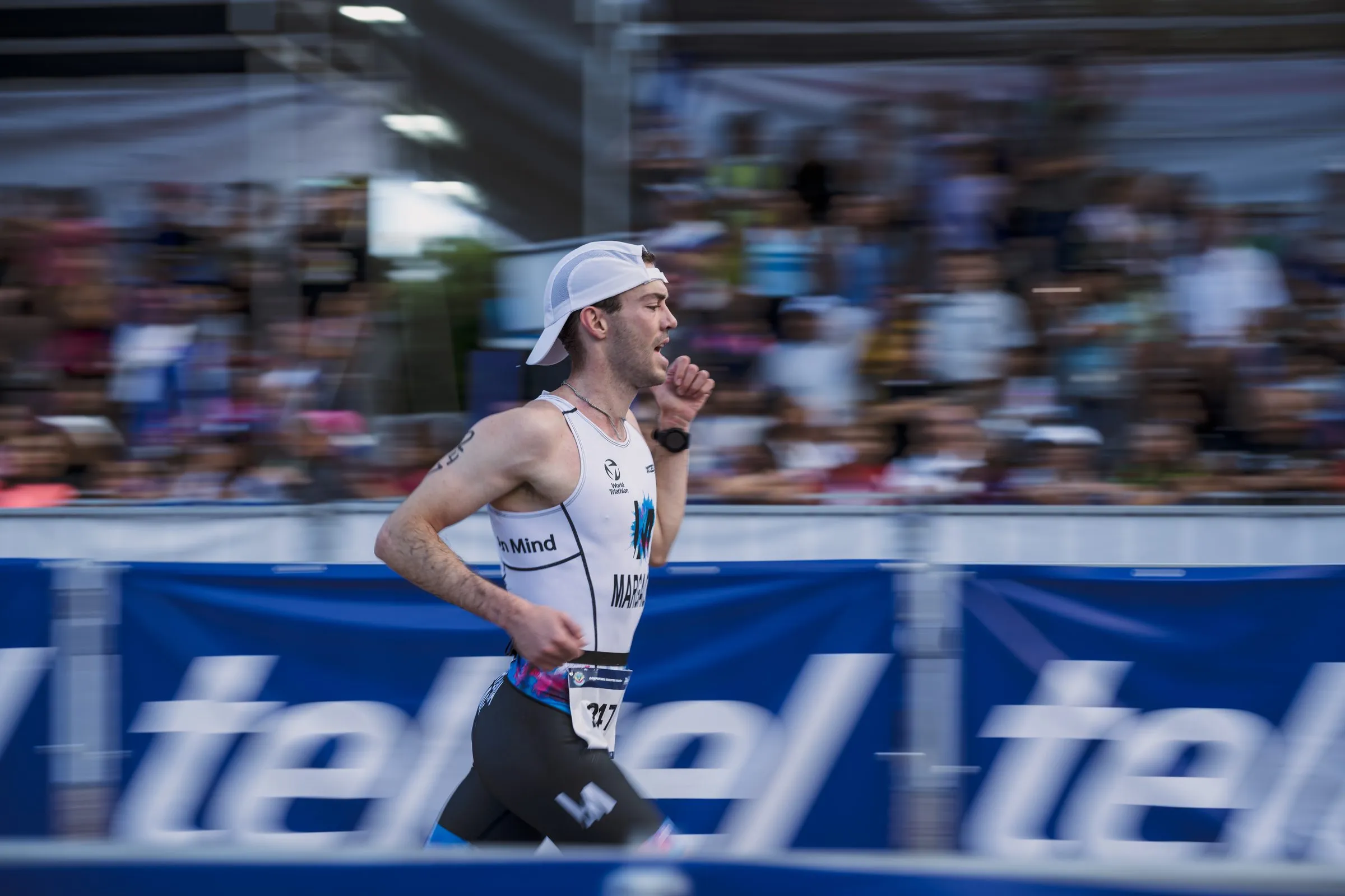 Atleta corriendo con banner de patrocinador visible en la ruta del triatlón en Xel-Há, Riviera Maya